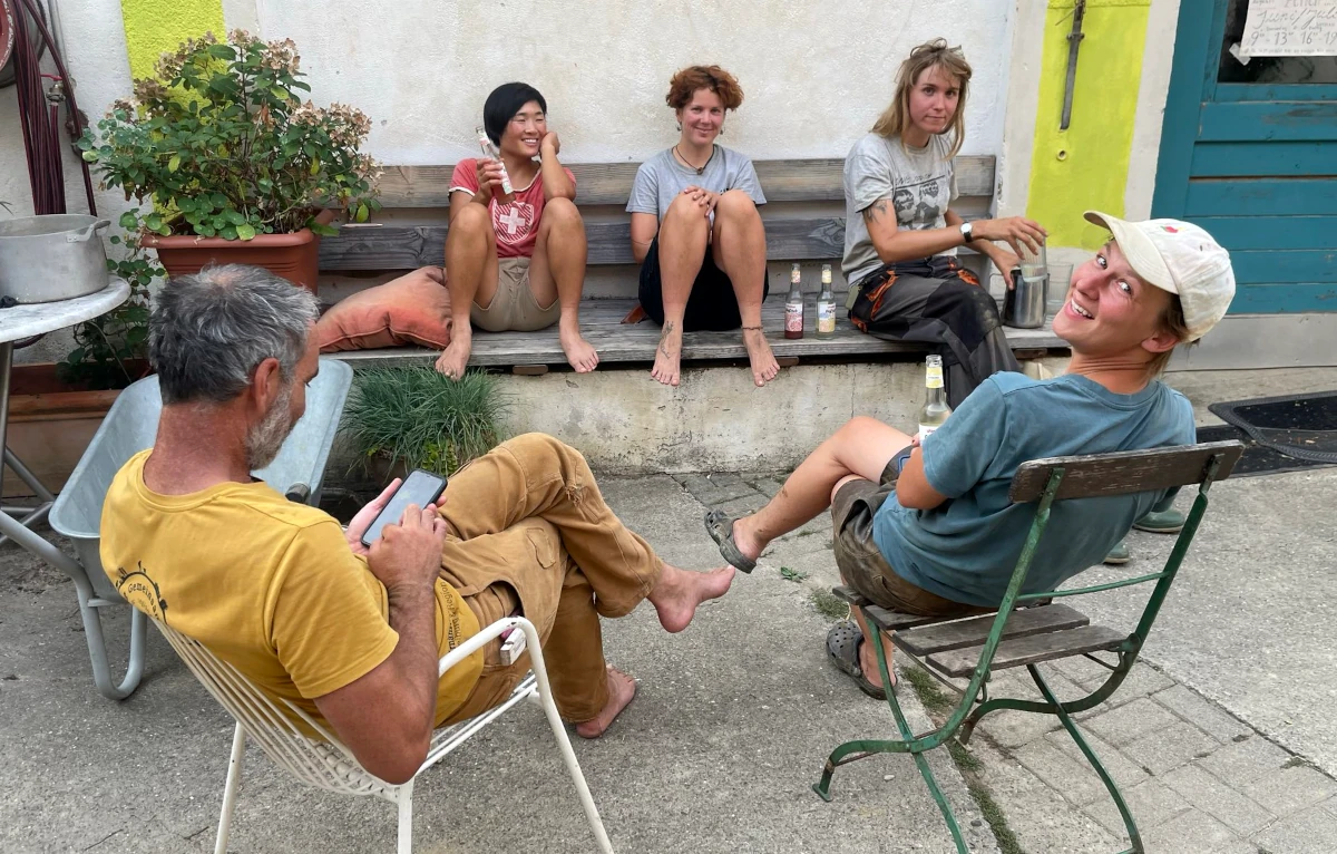 Eine Gruppe von fünf Mitgliedern des Hof-Teams macht eine entspannte Pause im Innenhof und genießt gemeinsam den Feierabend.